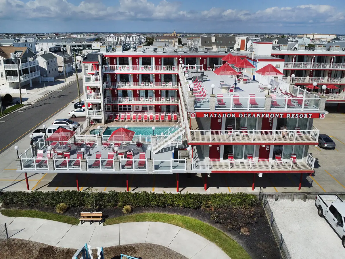 The Matador Oceanfront Resort seen from the beach side, its red MATADOR OCEANFRONT RESORT sign facing the boardwalk, with the pool deck below