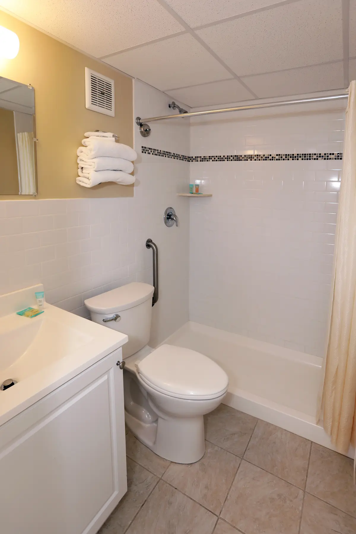 A tiled guest bathroom at the Matador Oceanfront Resort, with a shower-over-bath and vanity