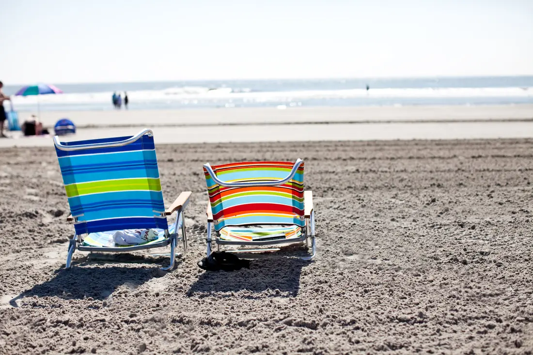 Two striped beach chairs set up on the wide North Wildwood sand, facing the surf