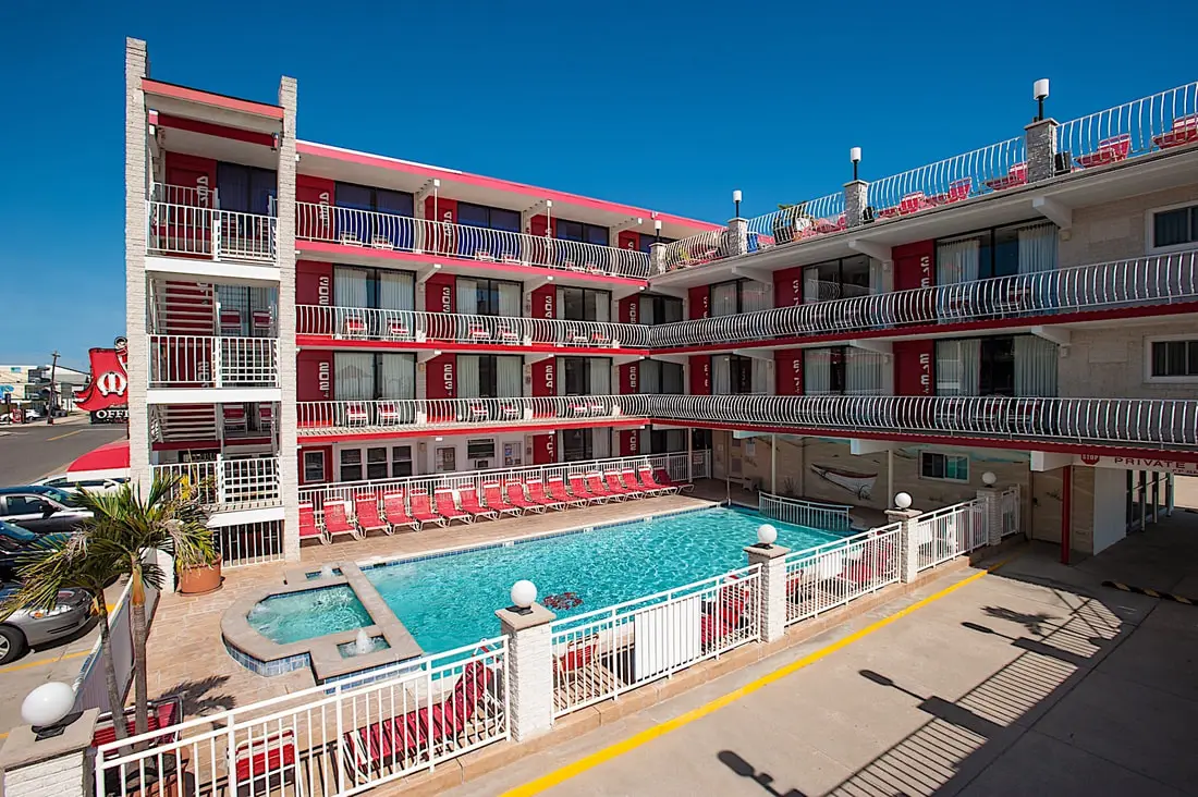 The front exterior of the Matador Oceanfront Resort seen from the lower sundeck, red awnings over the office entrance