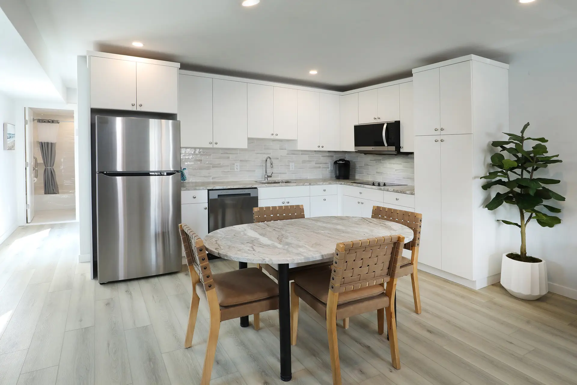 The dining table and full kitchen in a renovated apartment at the Matador, with stainless appliances and stone worktops