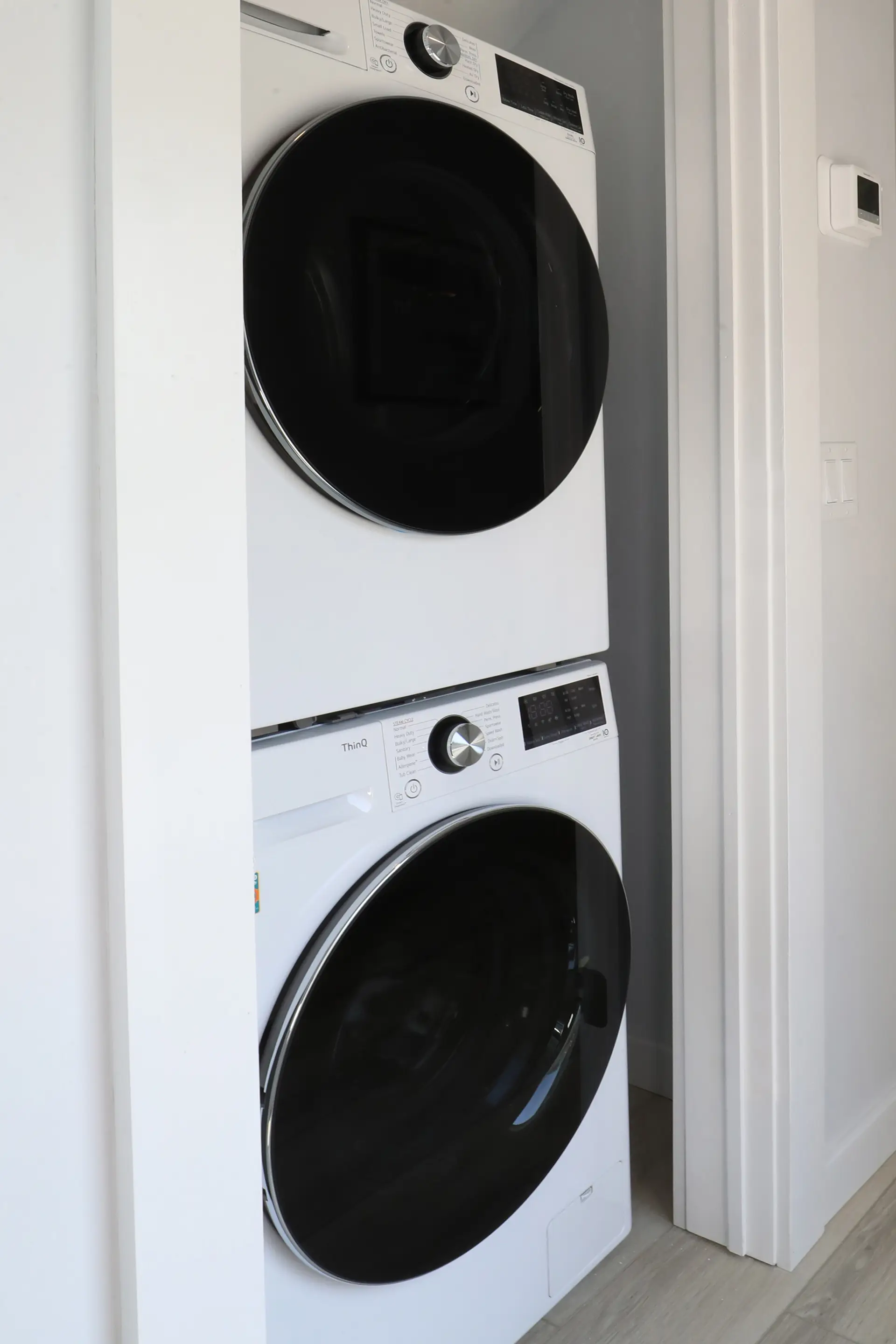 A stacked washer and dryer in the utility closet of a renovated apartment at the Matador