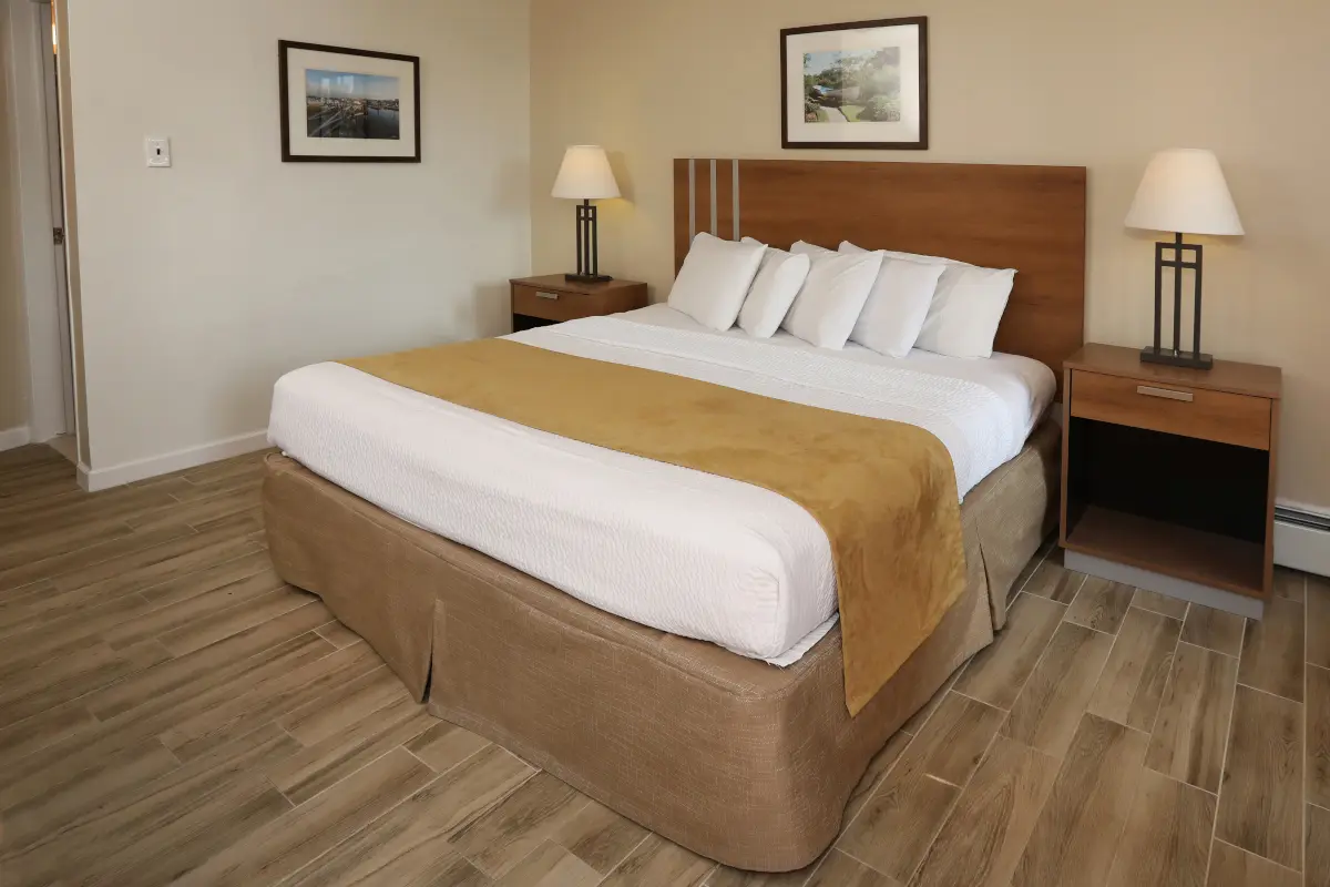 Type 11 Ocean View or Pool View Motel Room at the Matador, with a king bed, bedside lamps and framed prints of the shore