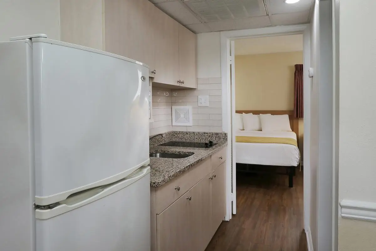 The kitchenette in a Type 4 Two-Room Efficiency at the Matador, with full-size refrigerator, cooktop and cabinets