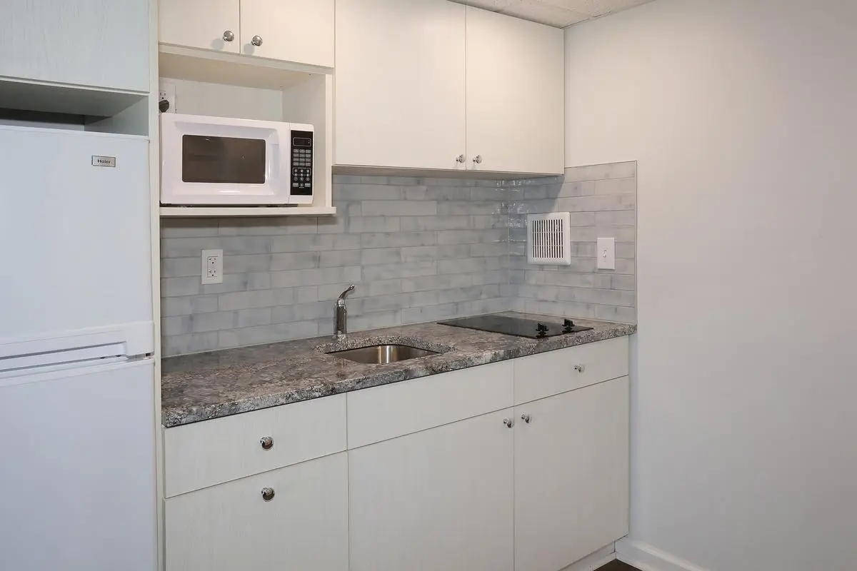 The kitchen in a Type 7 Ocean Front Beach Suite at the Matador, with full-size refrigerator, cooktop and microwave