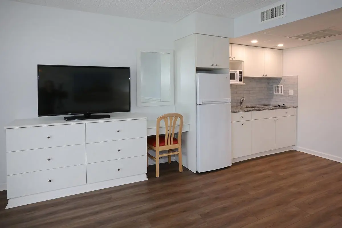The living room of a Type 7 Ocean Front Beach Suite at the Matador, with a sofa and sliding doors onto the oceanfront balcony