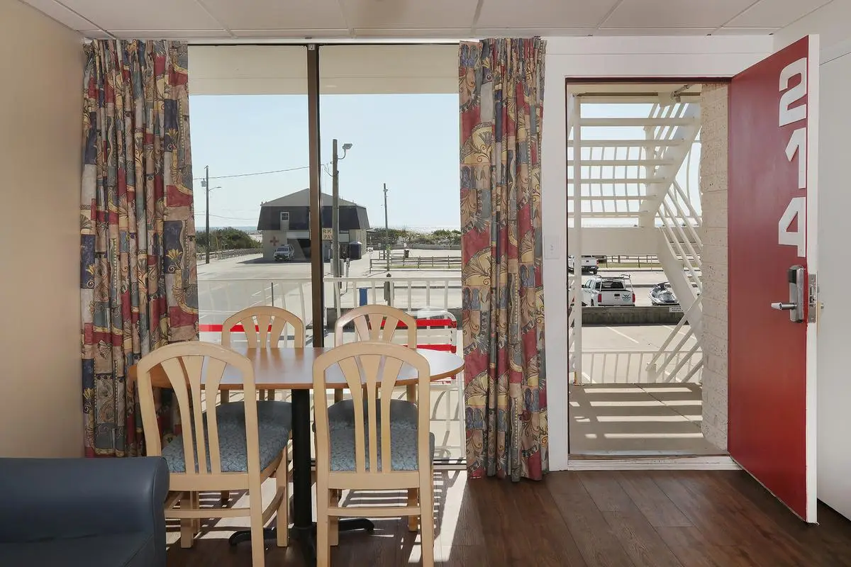 The living room of a Type 8 Three-Room Deluxe Apartment at the Matador, with a sofa, armchairs and a dining table